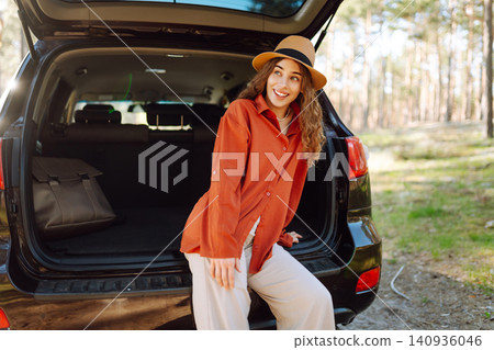 Road trips summer holidays. Woman enjoying nature while sitting in the trunk of her car 140936046
