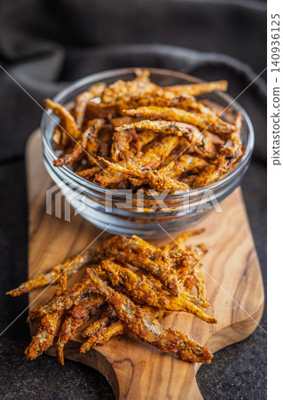 Crispy Fried smelts In Glass Bowl And On Wooden Board, Crunchy Seafood Snack Crispy Fried smelts In Glass Bowl And On Wooden Board, Crunchy Seafood Snack 140936125