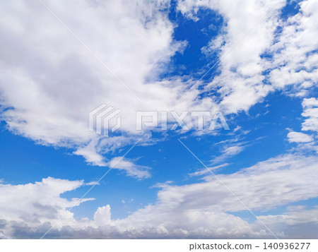 This bright blue sky filled with fluffy white clouds on a sunny day brings a peaceful sense of freedom and hope. Perfect as an uplifting background for creative projects. No people. This bright blue sky filled with fluffy white clouds on a sunny day brings a peaceful sense of freedom and hope. Perfect as an uplifting background for creative projects. No people. 140936277