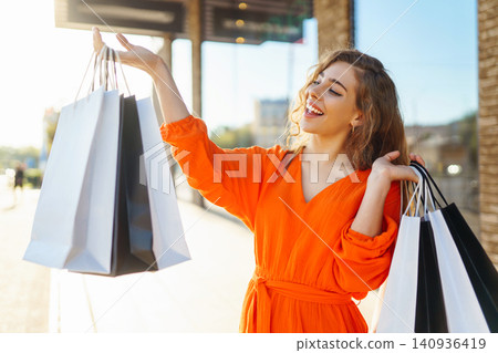 Young woman with shopping bags near mall. Summer Style. Shopping, lifestyle, sale concept. Young woman with shopping bags near mall. Summer Style. Shopping, lifestyle, sale concept. 140936419