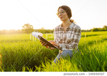 Farmer touches wheat sprouts, checking growth. Concept for farm development, horticulture. 140936507