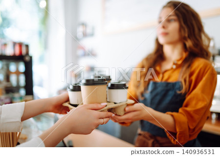 The coffee shop owner gives orders to go. Takeaway drinks concept, small business. The coffee shop owner gives orders to go. Takeaway drinks concept, small business. 140936531