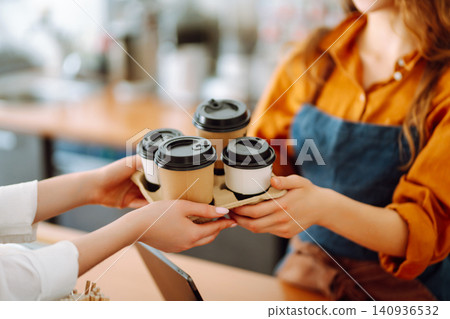 The coffee shop owner gives orders to go. Takeaway drinks concept, small business. The coffee shop owner gives orders to go. Takeaway drinks concept, small business. 140936532