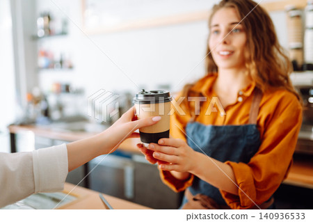 The coffee shop owner gives orders to go. Takeaway drinks concept, small business. The coffee shop owner gives orders to go. Takeaway drinks concept, small business. 140936533