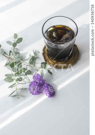 冰咖啡配藍盆花和尤加利樹葉；一張垂直餐桌照片，夏日的陽光傾瀉而入。 140936756