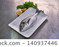 Sea bream fish on a white plate with parsley and lemon 140937446