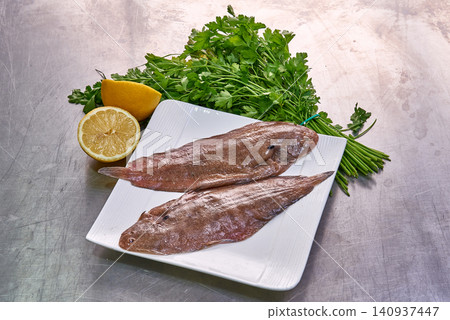 Sole fish on a white plate with parsley and lemon Sole fish on a white plate with parsley and lemon 140937447