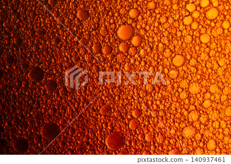 Close up of gold and orange oil bubbles in water creating an abstract macro texture with gradient lighting Close up of gold and orange oil bubbles in water creating an abstract macro texture with gradient lighting 140937461