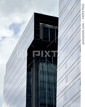 Symmetric Glass Curtain Wall Towers Under Blue Cloud Sky Symmetric Glass Curtain Wall Towers Under Blue Cloud Sky 140937602