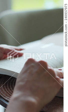 Vertical video Close-up unrecognizable woman reading a book. Vertical video Close-up unrecognizable woman reading a book. 140937973