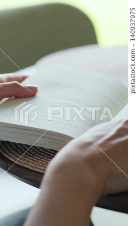 Vertical video Close-up of female hands turning page book. Woman reading book. Vertical video Close-up of female hands turning page book. Woman reading book. 140937975
