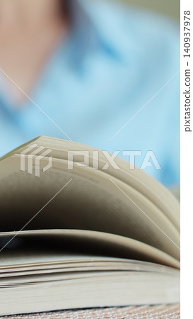 Vertical video Close-up of female hands turning page book. Woman reading book. Vertical video Close-up of female hands turning page book. Woman reading book. 140937978