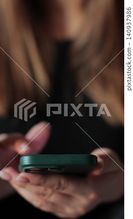 Vertical video Close-up young woman using smartphone in living room at home. Girl using texting mobile phone or chat. Chatting on social networks online. Vertical video Close-up young woman using smartphone in living room at home. Girl using texting mobile phone or chat. Chatting on social networks online. 140937986