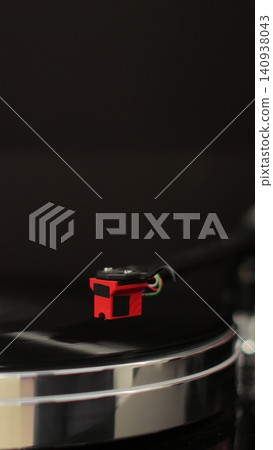 Vertical video Male hands operating vinyl record player with a vinyl disc. The needle rises from a vintage vinyl record. The vinyl record is spinning. Vertical video Male hands operating vinyl record player with a vinyl disc. The needle rises from a vintage vinyl record. The vinyl record is spinning. 140938043