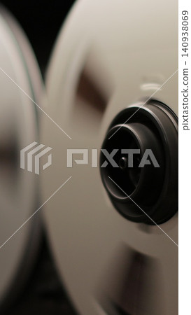 Vertical video Reel to reel tape recorder playing. Rotating vintage music player close up. Retro tape. Old school concept. Vertical video Reel to reel tape recorder playing. Rotating vintage music player close up. Retro tape. Old school concept. 140938069