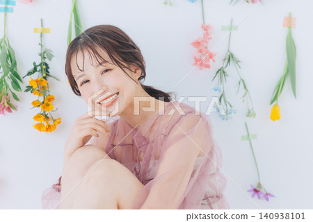 A young woman against a backdrop of colorful flowers A young woman against a backdrop of colorful flowers 140938101