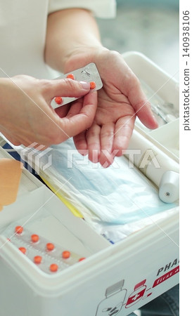 Vertical video Woman takes out blister of pills from first aid kit at home. Vertical video Woman takes out blister of pills from first aid kit at home. 140938106