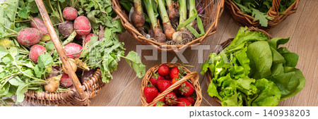 Baskets filled with fresh organic vegetables are placed on a wooden floor. Radishes, green onions, arugula, and lettuce create a colorful display of local produce, banner Baskets filled with fresh organic vegetables are placed on a wooden floor. Radishes, green onions, arugula, and lettuce create a colorful display of local produce, banner 140938203