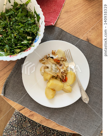 Boiled potatoes served with stewed vegetables and a fresh salad on a wooden table. This meal is suitable for those looking for a healthy and gluten-free option Boiled potatoes served with stewed vegetables and a fresh salad on a wooden table. This meal is suitable for those looking for a healthy and gluten-free option 140938319
