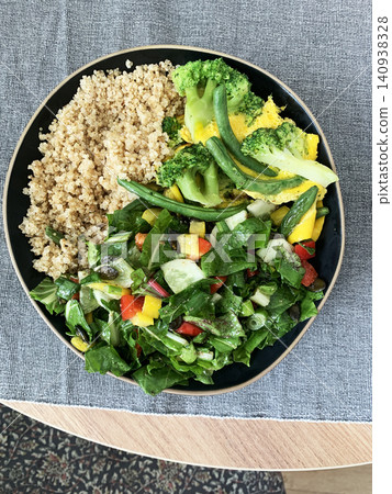 Quinoa bowl features boiled eggs, green beans, and broccoli. A fresh salad sits nearby. A cup of coffee completes the healthy breakfast setting Quinoa bowl features boiled eggs, green beans, and broccoli. A fresh salad sits nearby. A cup of coffee completes the healthy breakfast setting 140938328