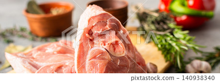 Turkey meat is placed on a wooden cutting board in a kitchen. Fresh herbs, garlic, and colorful vegetables surround the meat, adding to the cooking scene, banner Turkey meat is placed on a wooden cutting board in a kitchen. Fresh herbs, garlic, and colorful vegetables surround the meat, adding to the cooking scene, banner 140938340