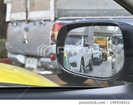 Car Side Mirror View Reflecting Heavy Traffic Jam On City Road Car Side Mirror View Reflecting Heavy Traffic Jam On City Road 140938422