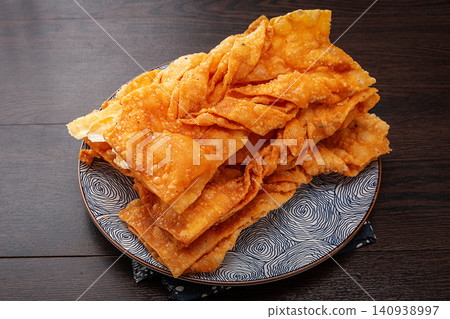 traditional Deep Fried Thin Crisp Ribbon Pastry, Golden Chinese Sweet and Savory Jiao Ye Snack 140938997