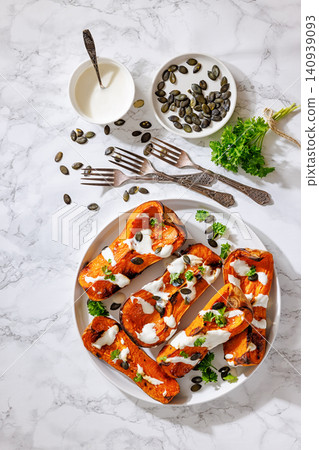 Baked butternut squash halves with yogurt sauce Baked butternut squash halves with yogurt sauce 140939093