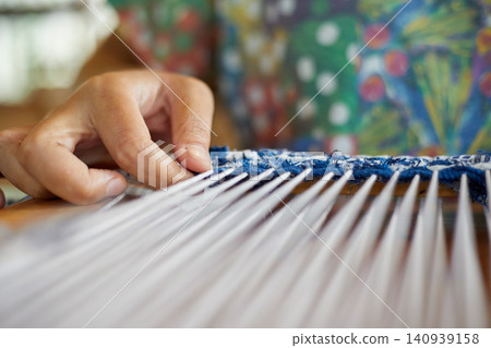 Weaving on a loom frame Weaving on a loom frame 140939158