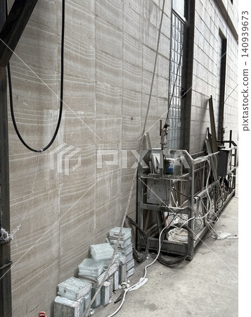 Industrial warehouse interior with metal structures and cables creates an unfinished, raw atmosphere Industrial warehouse interior with metal structures and cables creates an unfinished, raw atmosphere 140939673