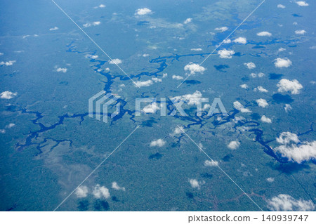 Aerial view over immense Amazon rainforest with a dark river cutting through forest. Amazonas, Brazil Aerial view over immense Amazon rainforest with a dark river cutting through forest. Amazonas, Brazil 140939747