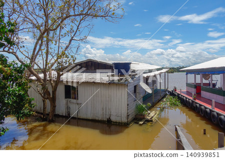 Floating wooden houses of riverside dwellers on banks of tropical river. nearby Manaus, Brazil Floating wooden houses of riverside dwellers on banks of tropical river. nearby Manaus, Brazil 140939851