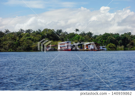 Floating wooden houses of riverside dwellers on banks of tropical river. nearby Manaus, Brazil Floating wooden houses of riverside dwellers on banks of tropical river. nearby Manaus, Brazil 140939862