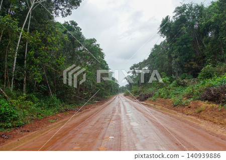 dirt and mud road cuts through Amazon rainforest in Brazil dirt and mud road cuts through Amazon rainforest in Brazil 140939886