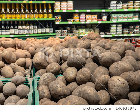 Fresh raw potatoes stacked in green plastic crates at a supermarket display aisle, conveying grocery shopping, organic produce, agricultural supply and healthy food inventory Fresh raw potatoes stacked in green plastic crates at a supermarket display aisle, conveying grocery shopping, organic produce, agricultural supply and healthy food inventory 140939973