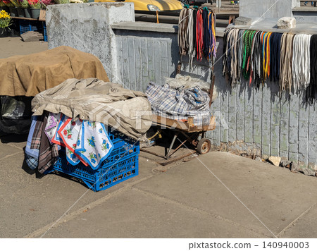 Street vendor cart displaying assorted shoelaces and fabrics on a city sidewalk for local market trade, reflecting small business commerce and authentic urban shopping atmosphere Street vendor cart displaying assorted shoelaces and fabrics on a city sidewalk for local market trade, reflecting small business commerce and authentic urban shopping atmosphere 140940003