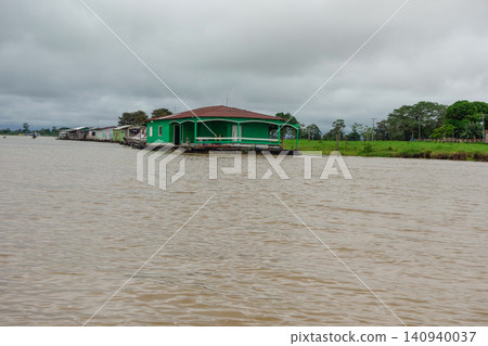 wooden stilt houses belonging to riverside dwellers along banks of tropical river. nearby Manaus, Brazil wooden stilt houses belonging to riverside dwellers along banks of tropical river. nearby Manaus, Brazil 140940037