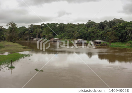 flooded riverbanks of amazon rainforest with riverside wooden houses, nearby Manaus, Brazil flooded riverbanks of amazon rainforest with riverside wooden houses, nearby Manaus, Brazil 140940038
