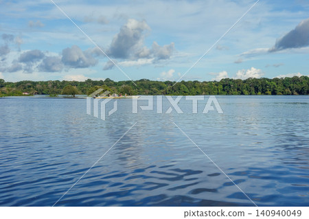 canoe with tourists sails on river that cuts through Amazon rainforest in Brazil canoe with tourists sails on river that cuts through Amazon rainforest in Brazil 140940049