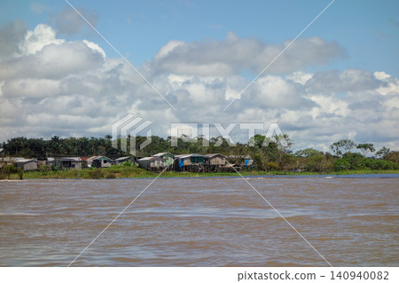 wooden stilt houses belonging to riverside dwellers along banks of tropical river. nearby Manaus, Brazil wooden stilt houses belonging to riverside dwellers along banks of tropical river. nearby Manaus, Brazil 140940082