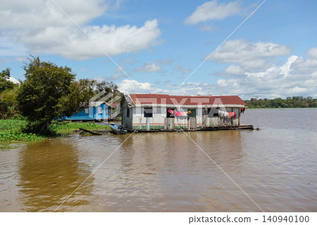 Floating wooden houses of riverside dwellers on banks of tropical river. nearby Manaus, Brazil Floating wooden houses of riverside dwellers on banks of tropical river. nearby Manaus, Brazil 140940100