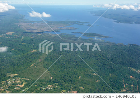 Aerial view over immense Amazon rainforest with a wide river cutting through forest. Amazonas, Brazil 140940105