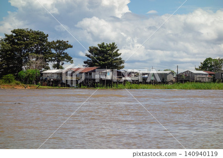 wooden stilt houses belonging to riverside dwellers along banks of tropical river. nearby Manaus, Brazil wooden stilt houses belonging to riverside dwellers along banks of tropical river. nearby Manaus, Brazil 140940119