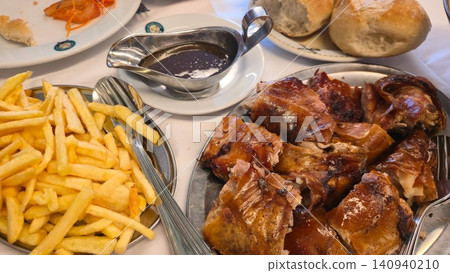 Traditional Portuguese meal with roasted suckling pig and creamy mushroom risotto served in a restaurant. Concepts: local cuisine, gastronomy, travel, culture, and dining. Traditional Portuguese meal with roasted suckling pig and creamy mushroom risotto served in a restaurant. Concepts: local cuisine, gastronomy, travel, culture, and dining. 140940210