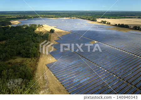 Aerial view of large sustainable electrical power plant with rows of solar photovoltaic panels for producing clean electric energy. Concept of renewable electricity with zero emission Aerial view of large sustainable electrical power plant with rows of solar photovoltaic panels for producing clean electric energy. Concept of renewable electricity with zero emission 140940343