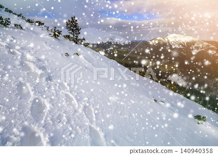 Small pine tree on snow covered hill in winter mountains Small pine tree on snow covered hill in winter mountains 140940358