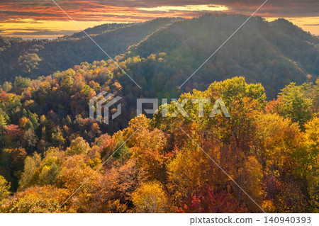 Appalachian mountain hills on autumn evening with brightly illuminated lush and pine woods at fall season. Autumnal landscape of beautiful nature Appalachian mountain hills on autumn evening with brightly illuminated lush and pine woods at fall season. Autumnal landscape of beautiful nature 140940393