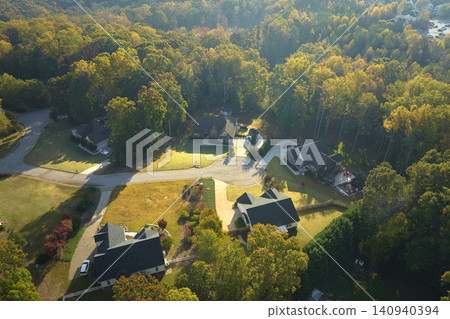 Aerial view of new family houses between yellow trees in South Carolina suburban area in fall season. Real estate development in american suburbs Aerial view of new family houses between yellow trees in South Carolina suburban area in fall season. Real estate development in american suburbs 140940394