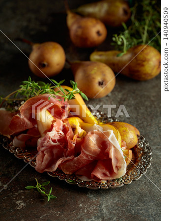 Prosciutto with pears and thyme on a silver tray. Prosciutto with pears and thyme on a silver tray. 140940509