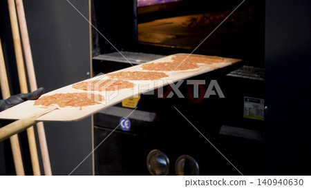 Man Preparing and baking pita kiymal pide and lahmacun. Turkish pizza in the oven video 140940630